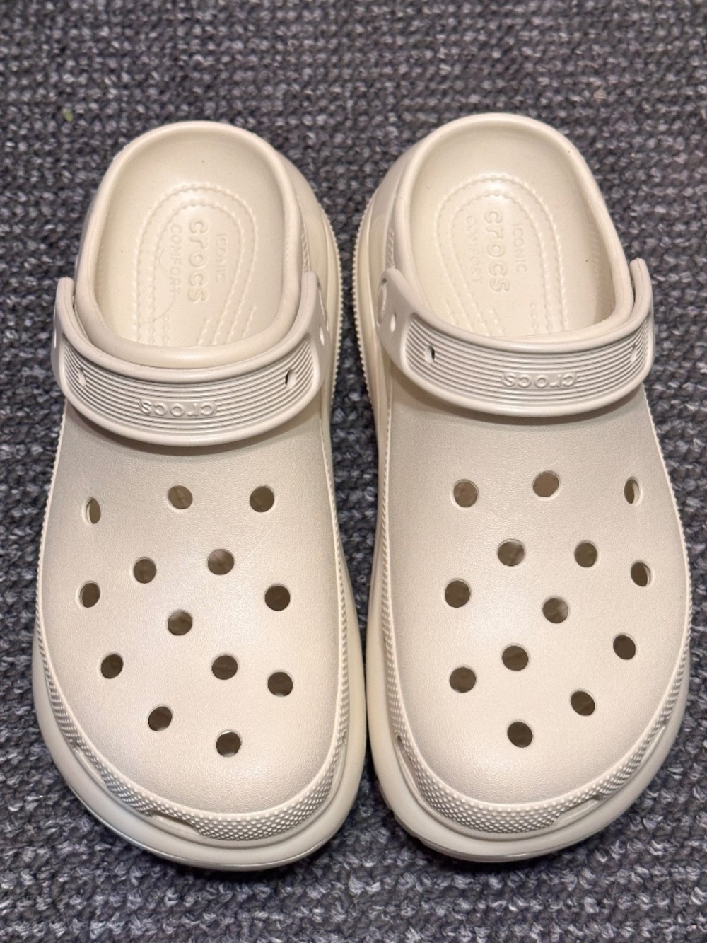 These bone-colored Crocs Mega Crush Clogs feature a distinctive chunky flatform